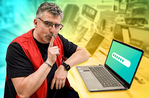 Vendeur Darty assis devant un PC portable avec un doigt sur la bouche