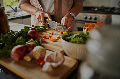 Le triangle d'activité permet d'optimiser la préparation des plats dans sa cuisine Une personne découpe des légumes avec un couteau