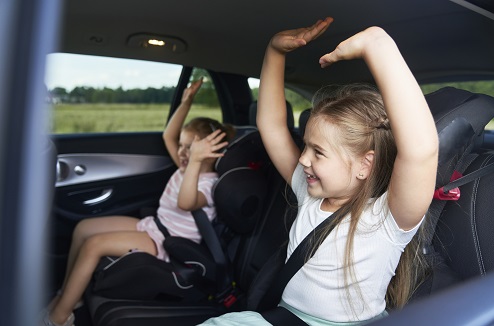 Occuper les enfants en voiture n'est pas simple Deux enfants s'amusent dans une voiture