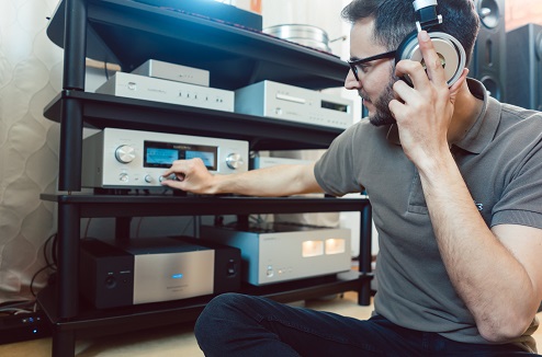 Homme réglant son amplificateur hifi