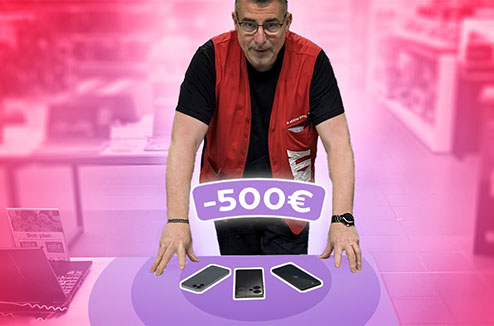 Vendeur Darty devant une table avec 3 telephones portables à - de 500 euros