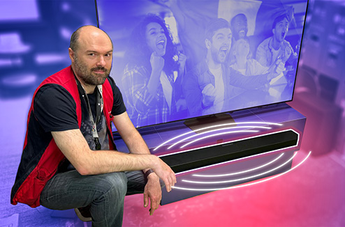 Il faut bien choisir sa barre de son pour profiter au mieux des évènements sportifs à la TV Vendeur Darty devant une barre de son et TV qui affiche une image de supporters