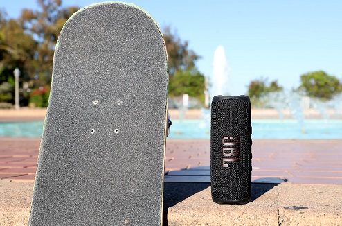 Enceinte jbl Flip 6 à cote d'un skate au bord d'une piscine