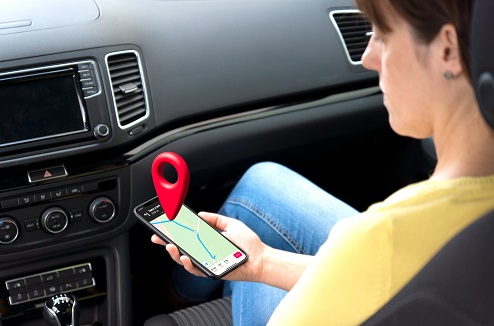 jeune femme s'orientant en voiture avec un smartphone