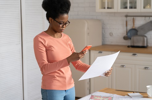 Jeune femme de couleur numérise un document avec son smartphone